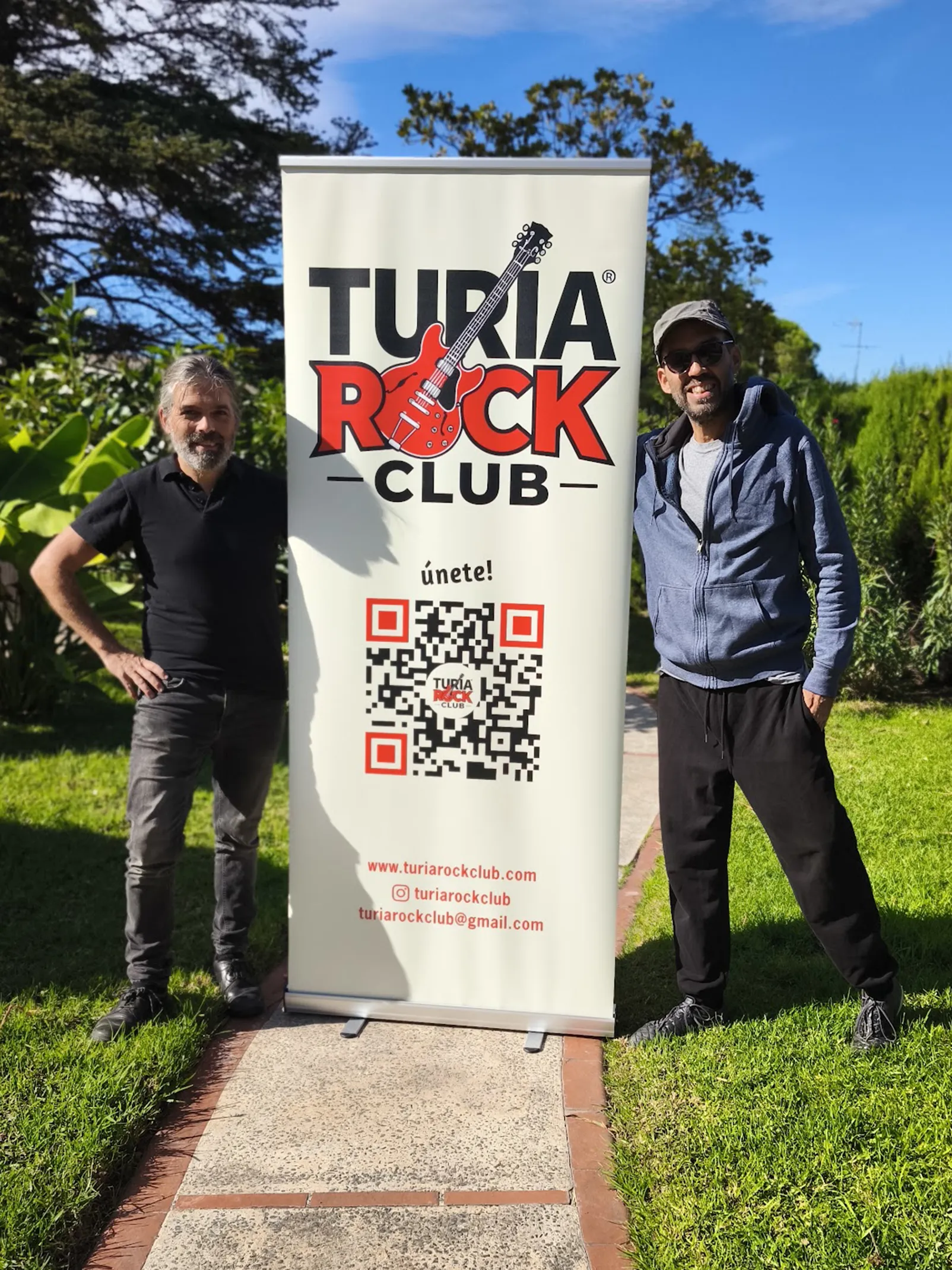 David Incertis y Ernesto Cidad junto al roll-up de Turia Rock Club en un jardín